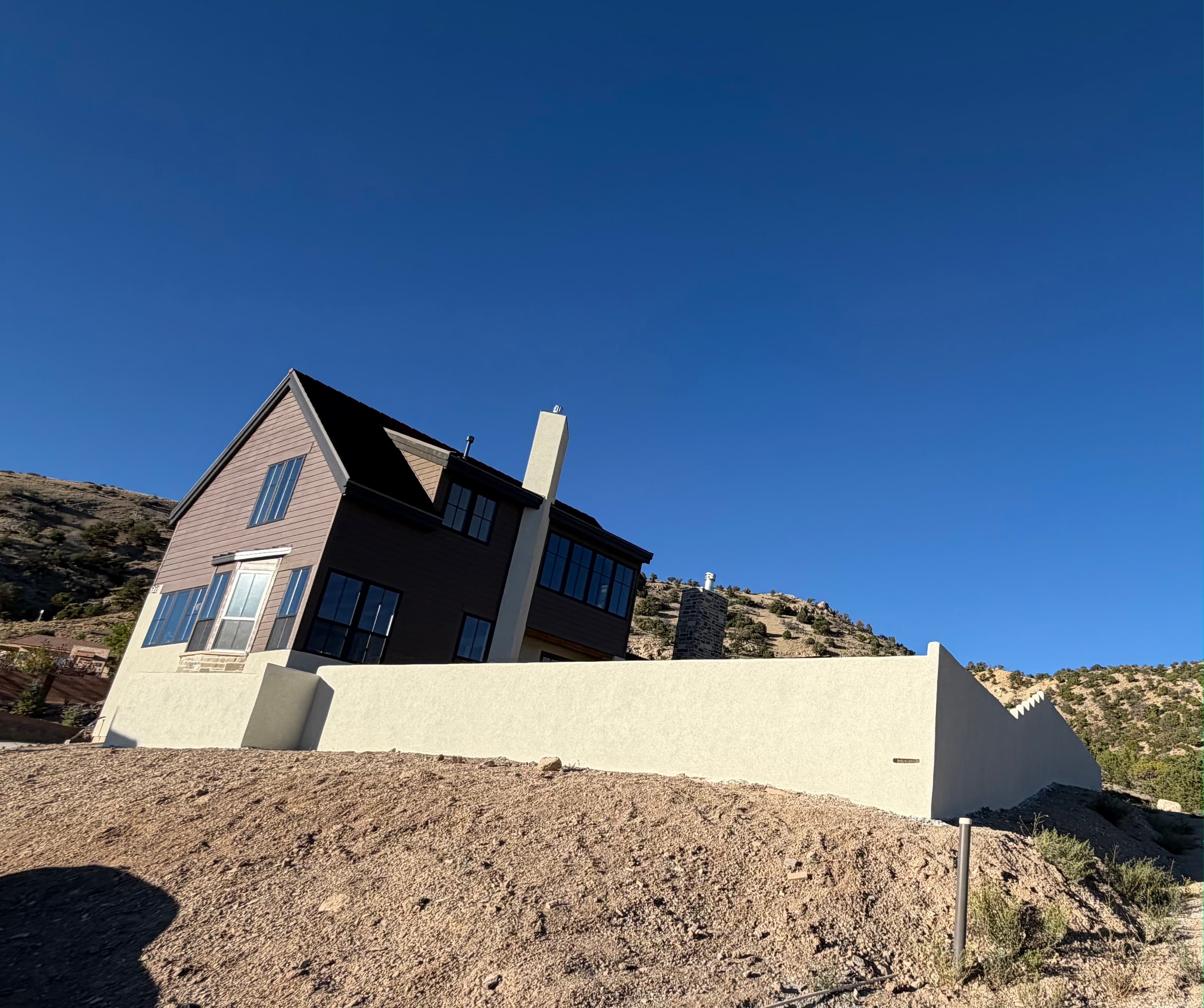 After: the same wall resurfaced in smooth stucco with a capped top